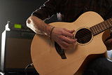 Close Up Of Man Playing Amplified Acoustic Guitar