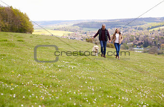 Mature Couple Taking Golden Retriever For Walk