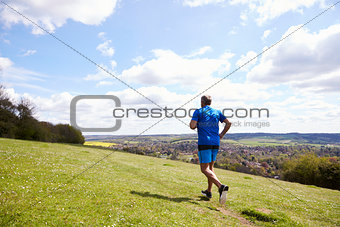 Rear View Of Mature Man Jogging In Countryside