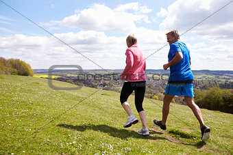 Rear View Of Mature Couple Jogging In Countryside