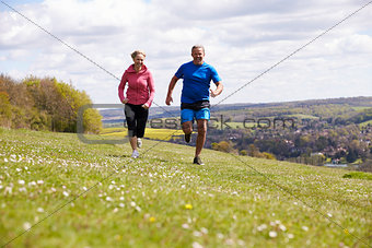 Mature Couple Jogging In Countryside