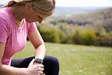 Mature Woman Checking Activity Tracker Whilst On Run
