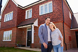 Portrait Of Young Couple Standing Outside New Home