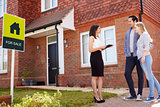 Realtor Outside House For Sale With Young Couple
