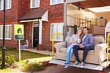 Couple With Sofa On Tail Lift Of Removal Truck Moving Home