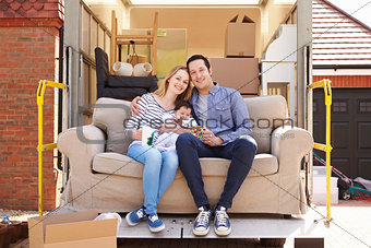 Family With Sofa On Tail Lift Of Removal Truck Moving Home