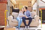 Couple With Sofa On Tail Lift Of Removal Truck Moving Home