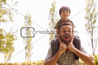 Father Giving Son Ride On Shoulders During Walk
