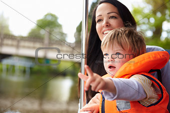 Mother And Son Enjoying Day Out In Boat On River Together