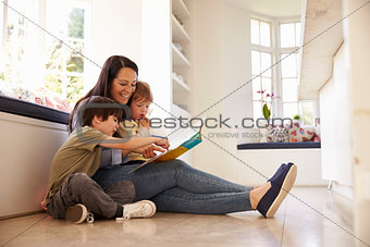 Mother And Sons Reading Story At Home Together