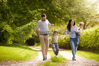 Family Going For Walk In Summer Countryside