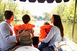 Family Enjoying Day Out In Boat On River Together
