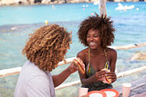 Mixed race couple having a meal by the sea, vertical, Ibiza