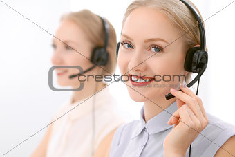 Call center. Focus on beautiful blonde woman in headset