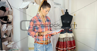 Woman with tablet in tailor\'s shop