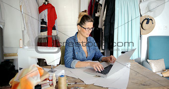 Tailor using laptop in parlour