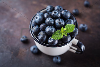 Freshly picked blueberries in a cup.