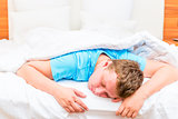 sleeping man on a white bed sheets
