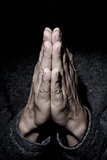 man praying with his hands put together