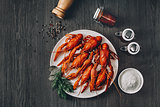Boiled big red fresh crawfish in white plate with green herbs
