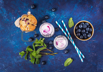 Natural yogurt with fresh blueberries and a muffin.