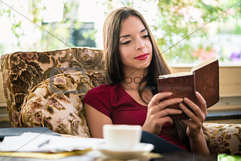 Attractive young woman reading a book