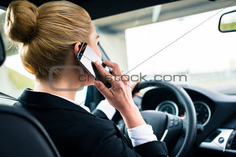 Woman using her phone while driving the car