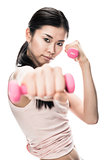 Young determined woman holding small dumbbells
