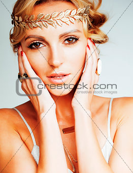 young blond woman dressed like ancient greek godess, gold jewelr