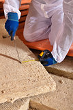 Man cutting rockwool panel to fit in thermal insulation layer