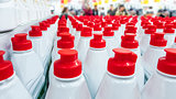 White plastic bottles with red lids in a row.