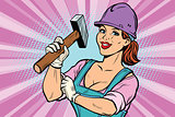 Construction worker with hammer. Woman professional