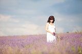 a pregnant woman in a field of flowers of lavender purple