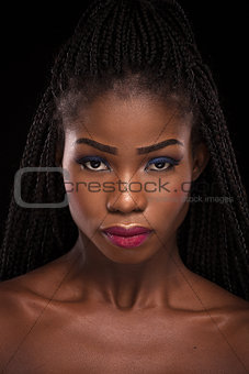 Dark skinned model posing on black background.