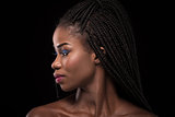 Dark skinned model with turning head to the left side on black backstage.