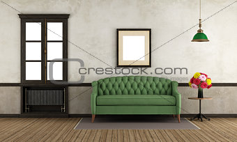 Empty retro room with green sofa and window