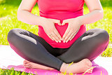 hands in the shape of a heart on the belly of a pregnant woman c