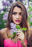 Portrait of young beautiful woman holding a lilac branch