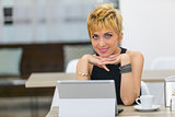 Smiling businesswoman sat at desk with computer