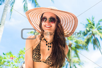 Woman with straw hat at the seaside, smiling