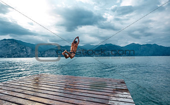 man jumping into the water from the pier