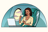 African Businesswoman in business class of the aircraft works at