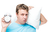 Man shows an alarm clock in the early morning, portrait with a p