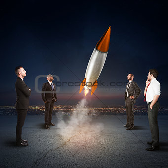 Team of businesspeople looks start a missile. Concept of company startup and new business. 3D Rendering.