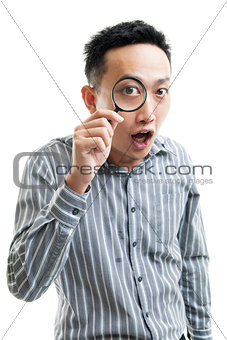 Asian businessman holding magnifier glass 