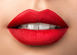 Close up view of beautiful woman lips with red matt lipstick
