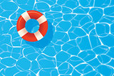 Red pool ring floating in a blue swimming pool. Summer backgroun