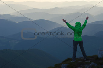 Tourist with outstretched hands in mountains