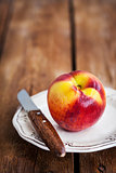 Fresh ripe peach on plate, wooden background