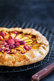 Galette with peach and raspberry on dark
